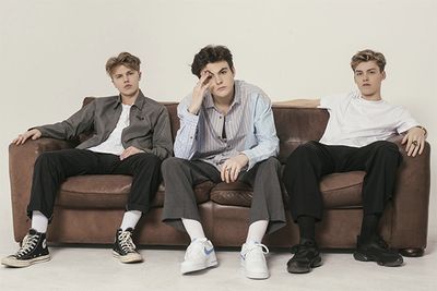 Image of New Hope Club band members sitting on a sofa